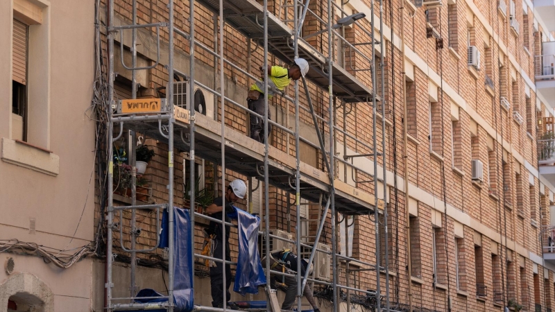 Un trabajador subido a los andamios de una obra, a 17 de mayo de 2023, en Barcelona.